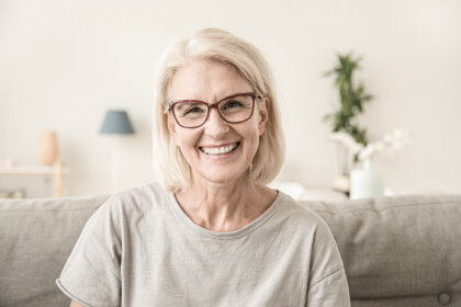 Ältere Patientin mit gesundem Lächeln als Symbol für erfolgreiche Parodontologie und stabilen Zahnhalt in der Zahnarztpraxis Dr. Tolk in Kreuzau